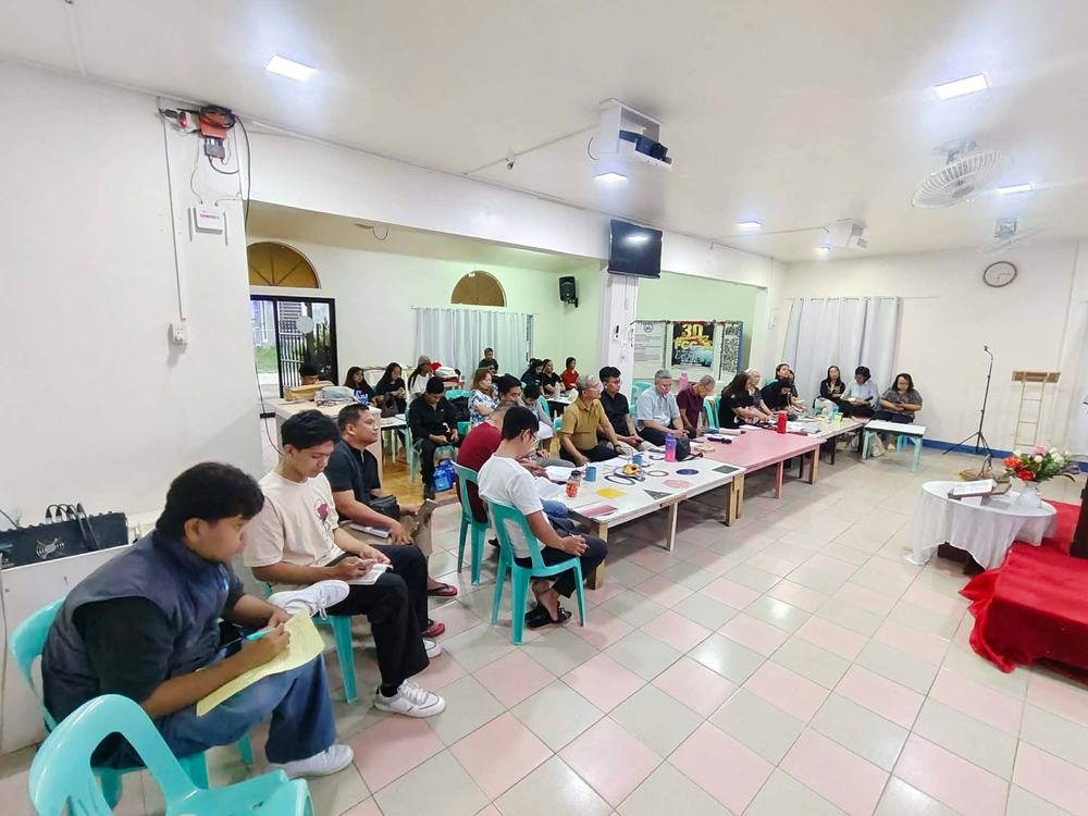 Students and pastors seated around tables in a face to face class